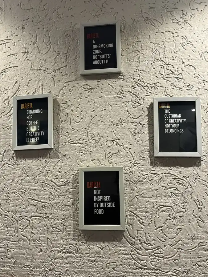 Framed signs on a textured cafe wall